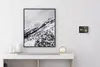 Ein elegantes Sideboard mit dekorativen Objekten, einer modernen Tischlampe und einem großformatigen monochromen Landschaftsbild darüber.