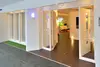 Toegang tot de smart home experience met glazen deuren, verlichting en een beplant stuk voor de ingang.